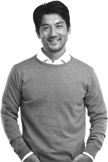 Photo of male professional in business casual shirt and sweater smiling with hands in pockets